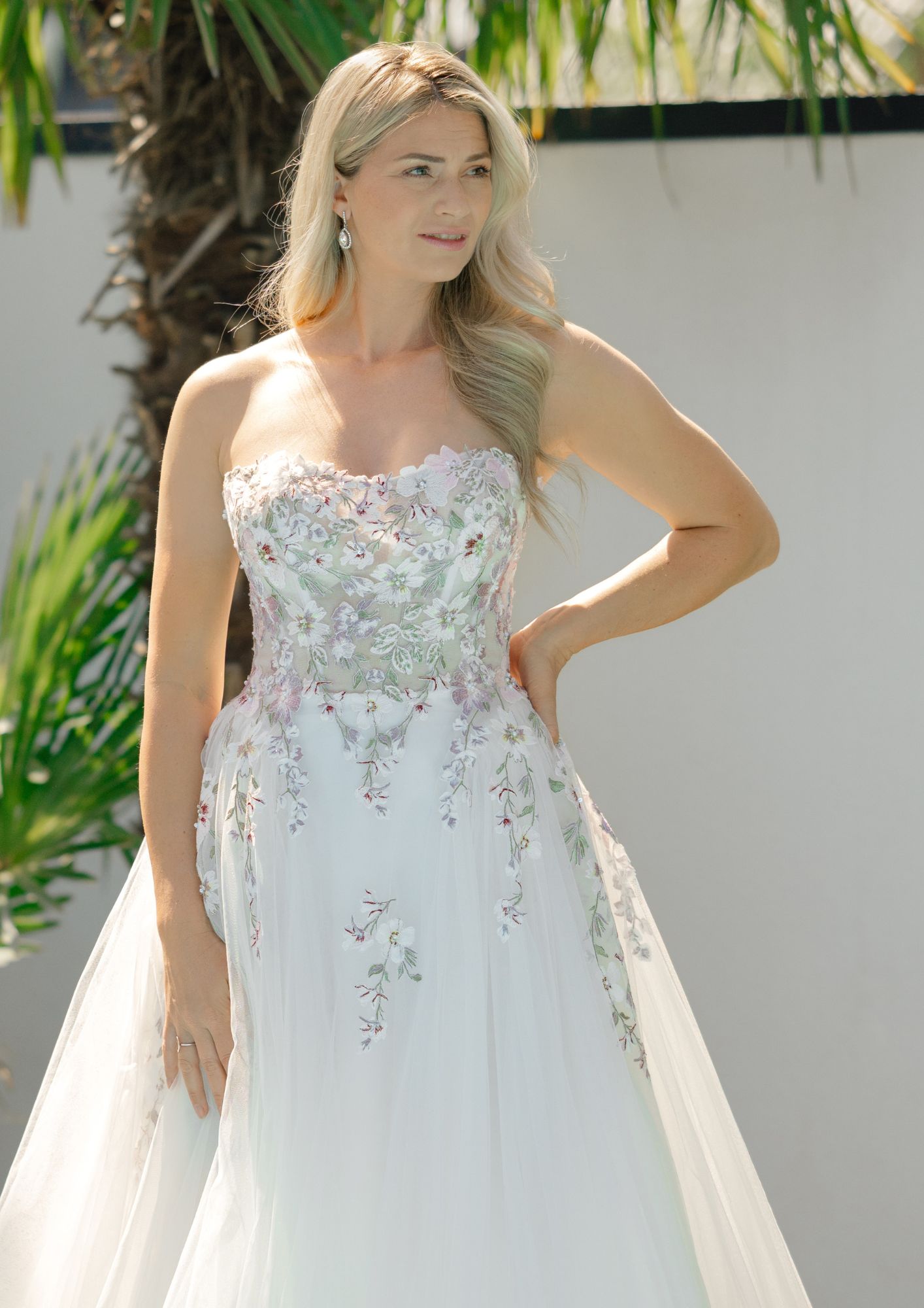 Brautkleid mit bunter Spitze. Die Blüten auf dem Brautkleid wurden farbig gestickt. Hochzeitskleid mit bunten Blumen.