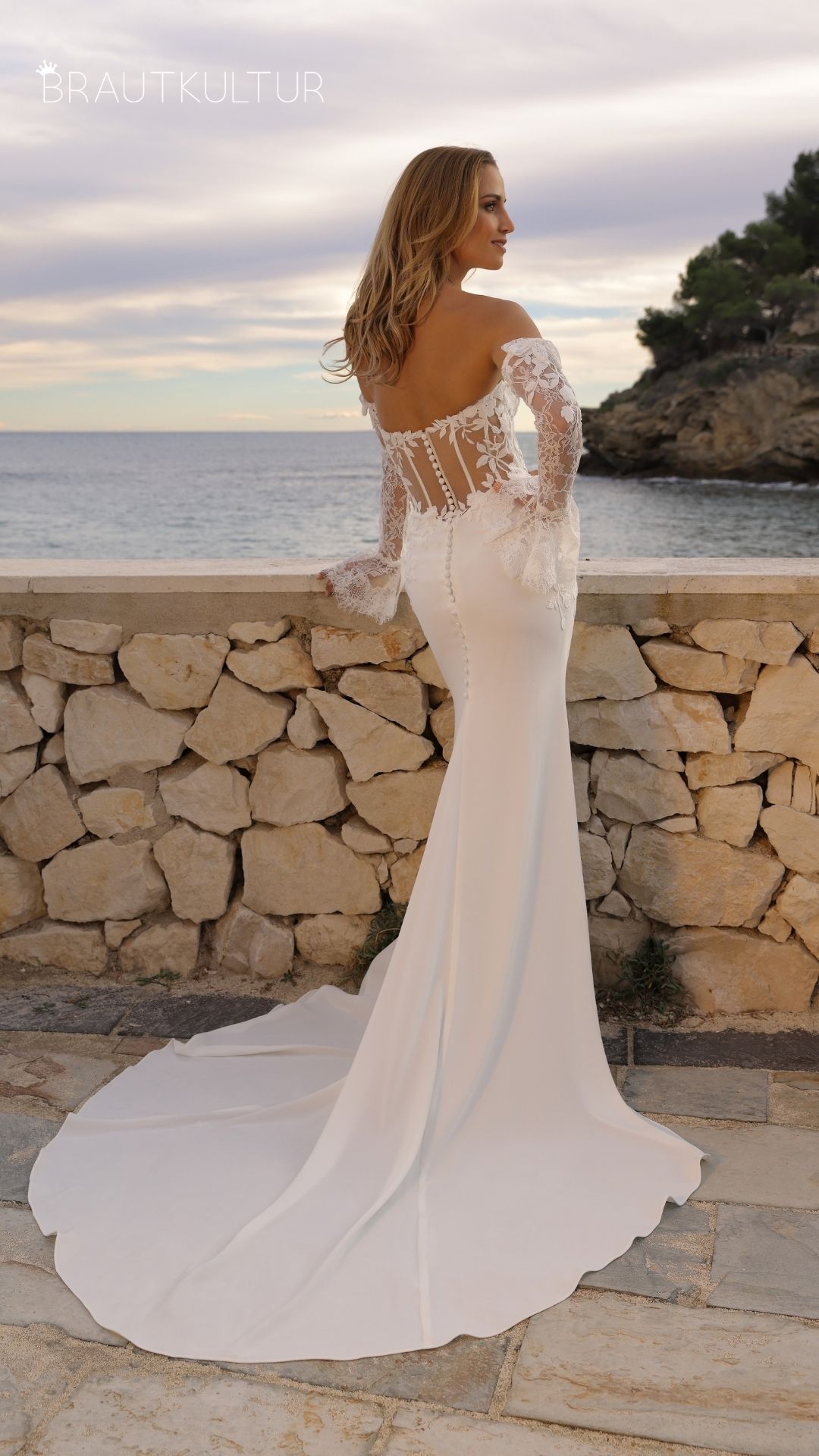 Dieses enge figurbetonende und atemberaubende Brautkleid setzt die Braut in den absoluten Vordergrund. Das Brautkleid mit der schönen Spitze und den Ärmeln ist gemacht für eine Diva die ihre Figur in Szene setzen möchte.